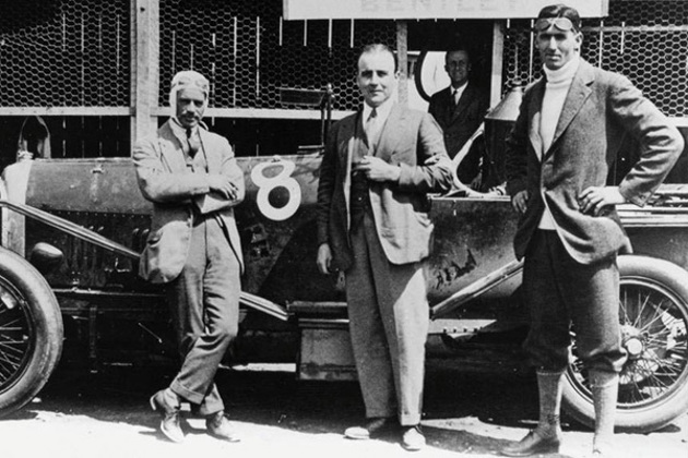 frank-clement-and-john-duff-standing-beside-a-racing-car-on-racing-track