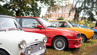 header-2-men-walking-beside-a-row-of-classic-cars-with-chateau-impney-in-the-background