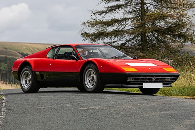 A red Ferrari 512 on a country track
