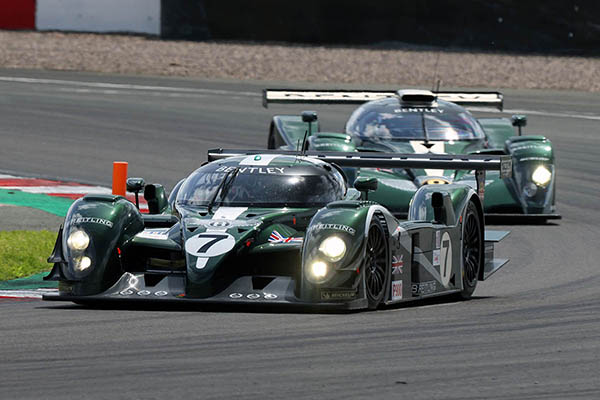 2 Green 2003 Bentley Speed 8S Turning A Corner One Behind The Other On A Racing Track
