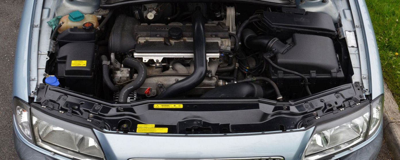 A light blue car with its bonnet open