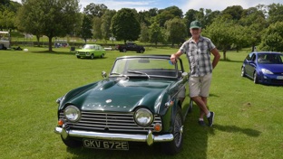 A Coffee and Chrome attendee posing with his green Triumph classic car