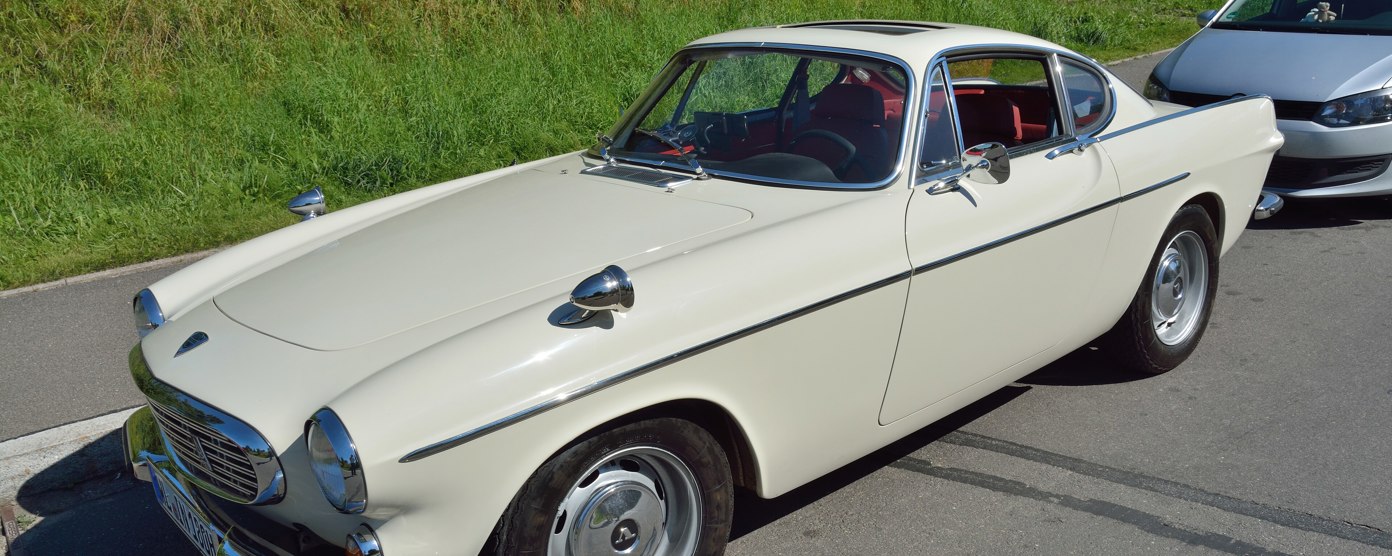 A cream classic car on a sunny roadside