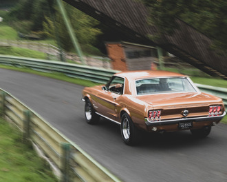 Copper 1967 Ford Mustang on a race track