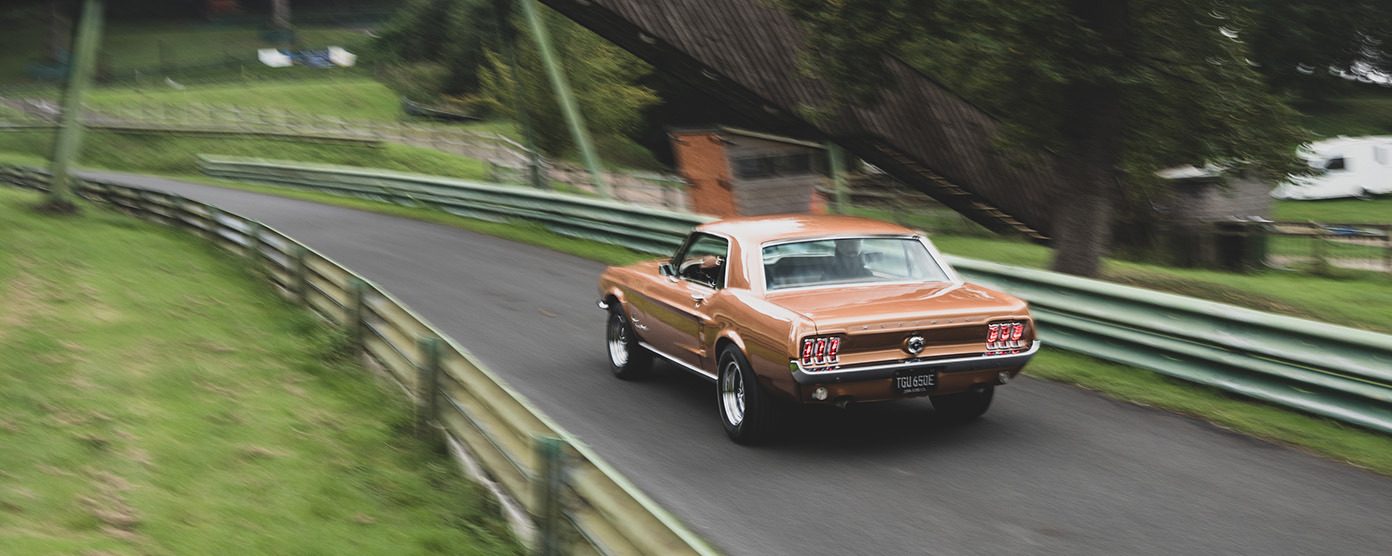 Copper 1967 Ford Mustang on a race track